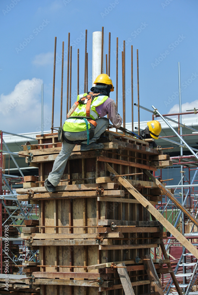MALACCA, MALAYSIA -MARCH 25, 2016: Construction workers fabricating timber form work at the construction site in Malacca, Malaysia. The form work was mainly made from timber and plywood. 
