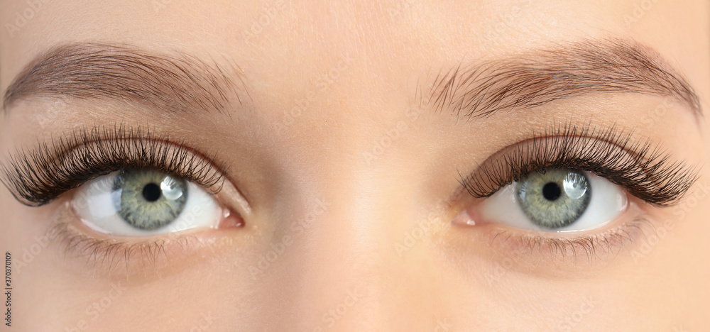 Obraz premium Young woman with beautiful long eyelashes, closeup view. Banner design