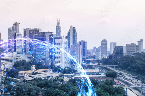 Abstract technology icons hologram over panorama city view of Kuala Lumpur, Malaysia, Asia. The concept of people networking and connections. Double exposure.