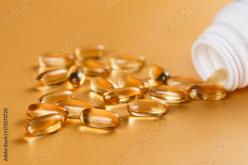 Many capsules Omega 3 on yellow background. Close up, high resolution product. Health care concept.