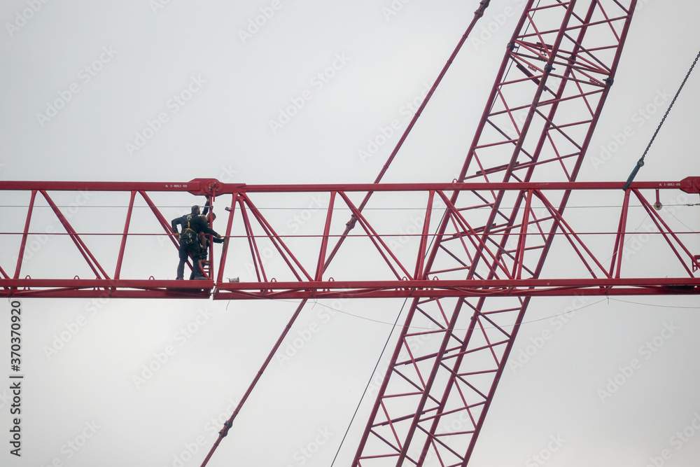 mutige Arbeiter montieren einen Kran auf einer Baustelle in Berlin. 
