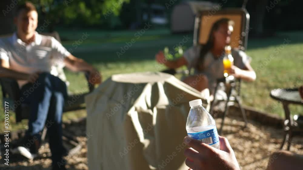Man drinking water bottle at a backyard summer hangout Man drinking water bottle at a backyard summer hangout