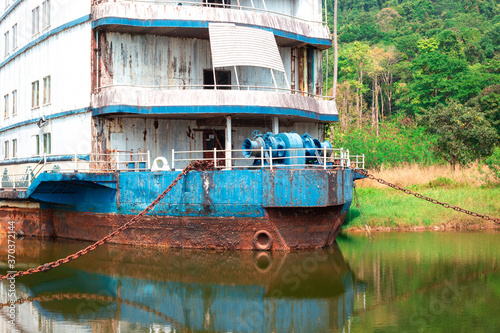 old rusty large ship stands in the creek. Travel and cruise concept