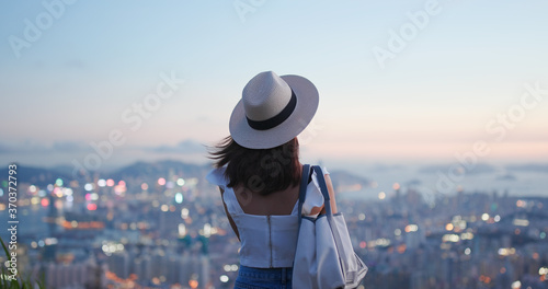 Woman look at the beautiful city view at sunset photo