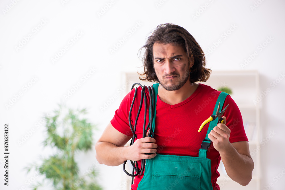 Funny young male electrician working indoors Funny young male electrician working indoors