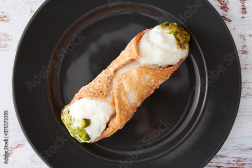 Sicilian cannoli filled with ricotta with chopped pistachios photo