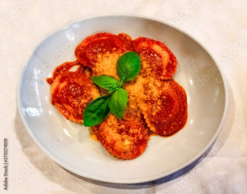 tasty first course with tomato, homemade ravioli with basil, parm  cheese, ricotta cheese, organic ingredients, typical Italian culinary specialties for lunch or dinner. Traditional and genuine dish photo