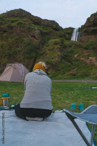 a woman having a picnic near Seljaalandsfoss waterfall