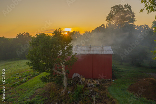 smoking red barn in the morning