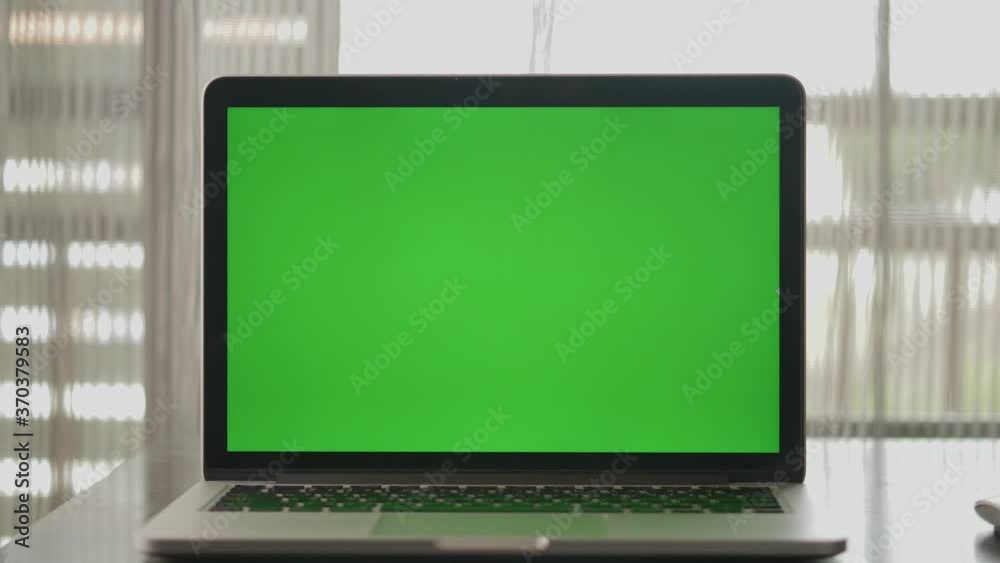 4K : A laptop computer with a key green screen set on work office table. 4K : A laptop computer with a key green screen set on work office table.