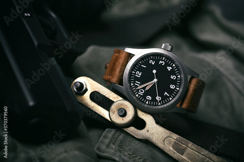 Field watch vintage style, Military wristwatch with leather strap and pistol. Classic mechanical timepiece, Men fashion and accessories.