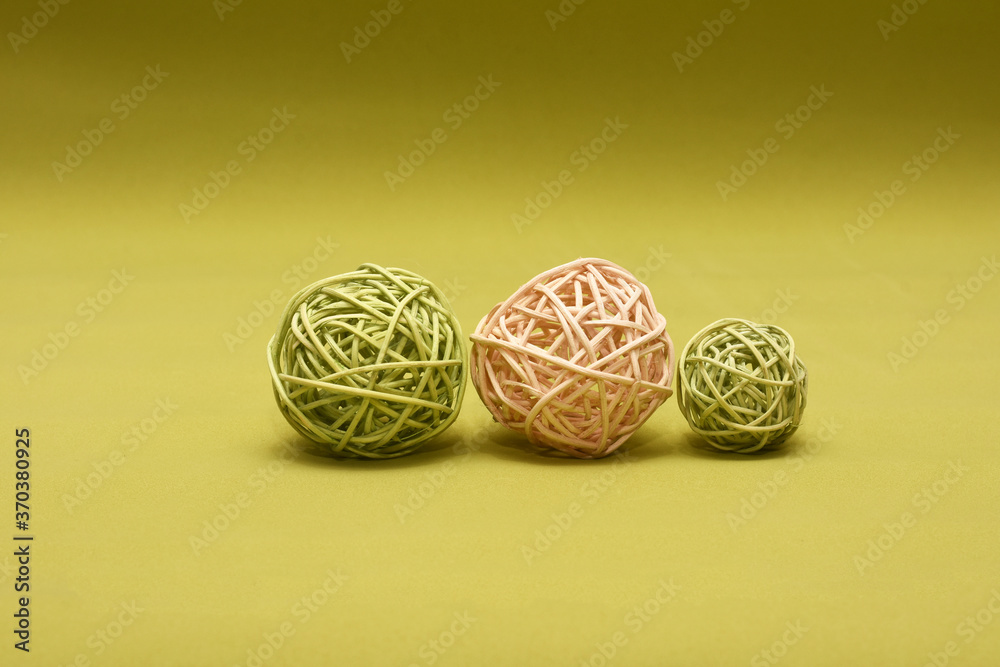 three braided balls of pink and green color on a green background three braided balls of pink and green color on a green background