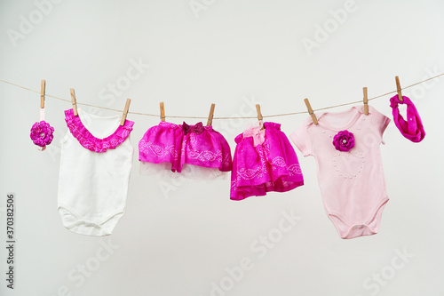 Baby clothes on a rope on a white background