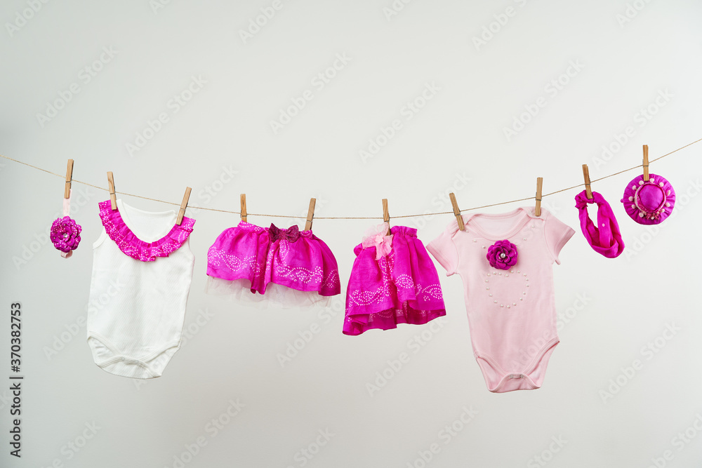 Baby clothes on a rope on a white background Baby clothes on a rope on a white background