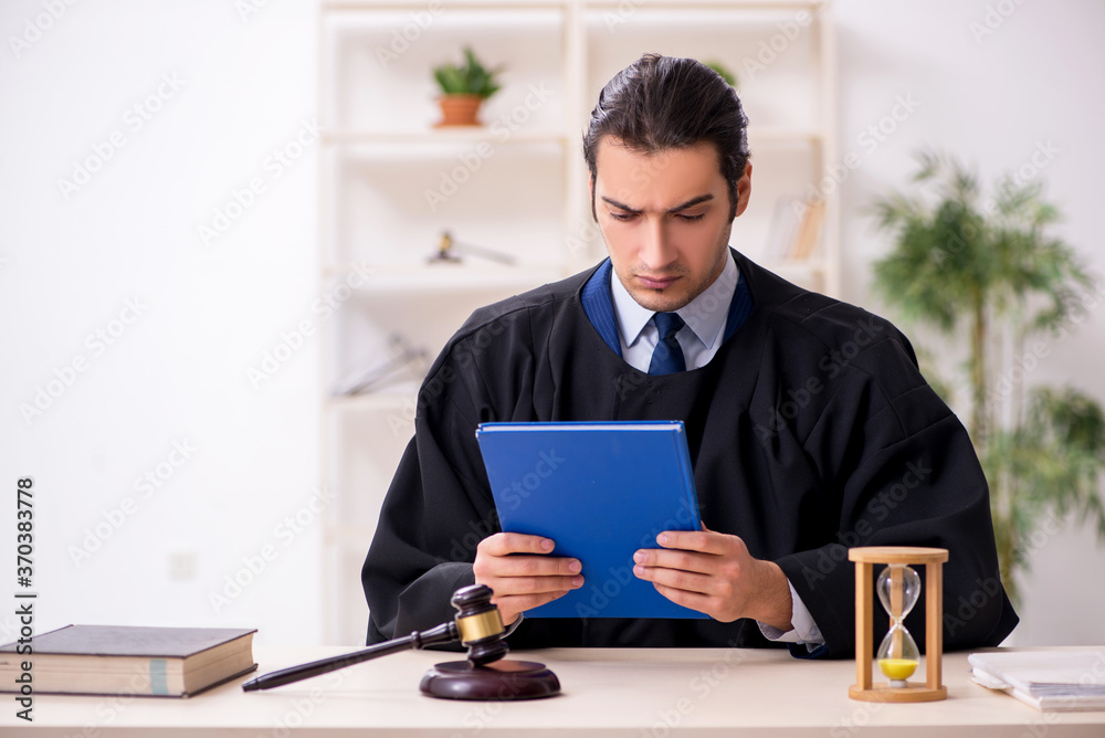 Young male judge in time management concept Young male judge in time management concept