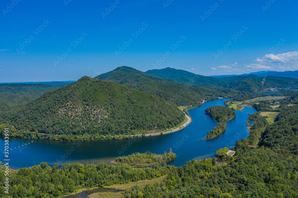 landscape with river, mountains, and blue sky