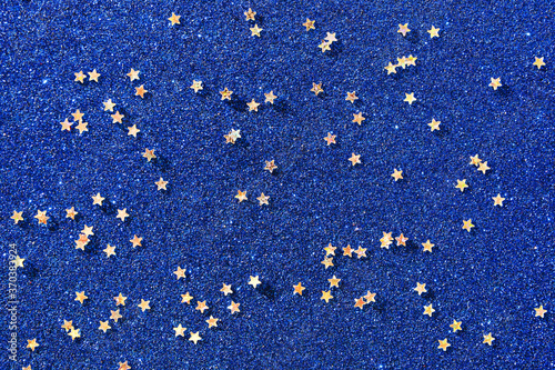Background of gold stars on colored paper with sequins