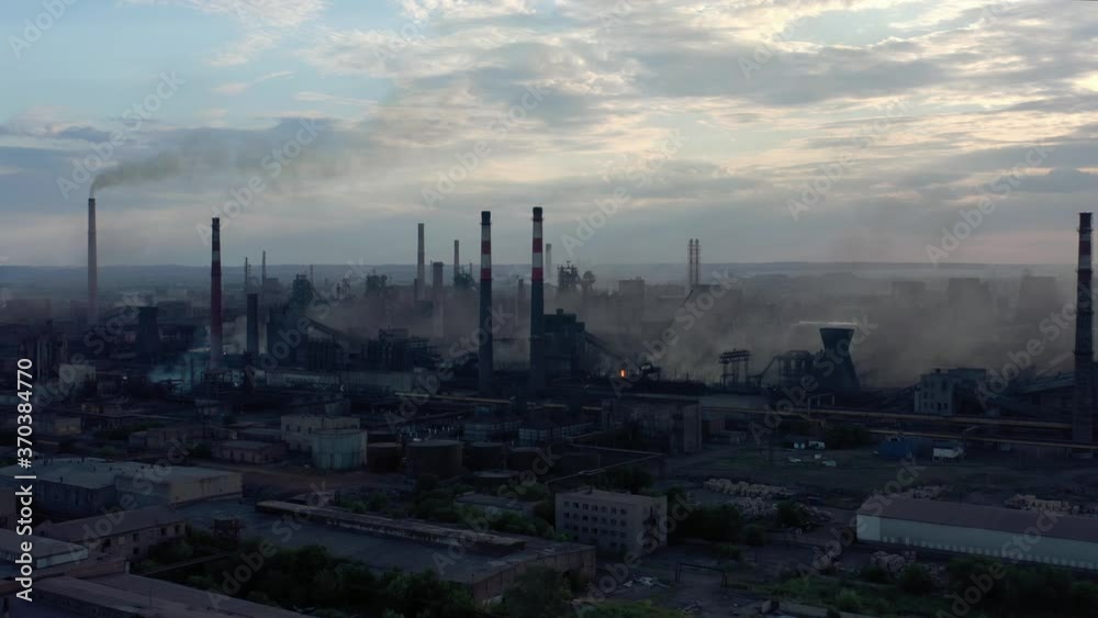 Drone aerial shot of industrial zone with thick smog and burning fossil fuels near water. Factory zone zoom out fly over of polluted city, many factory chimneys in city area Drone aerial shot of industrial zone with thick smog and burning fossil fuels near water. Factory zone zoom out fly over of polluted city, many factory chimneys in city area