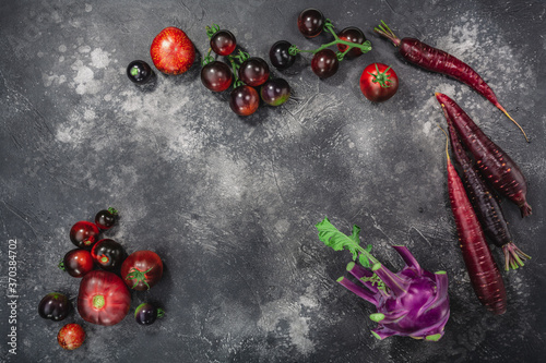 Anthocyanin-rich vegetables on dark textured backdrop, top view