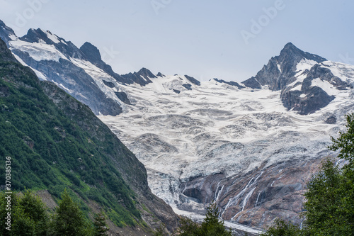 Beautiful landscape of glacier in summer season. Glacier mountain with green vegetation on high ground in cloudy weather. © Anton Dios
