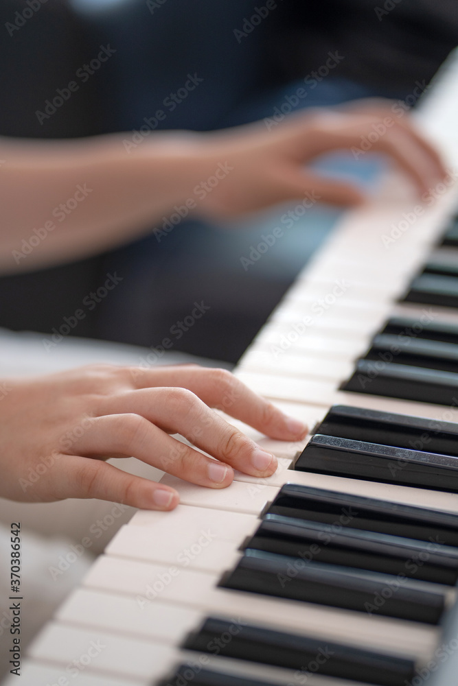 close up of kid hands playing  piano