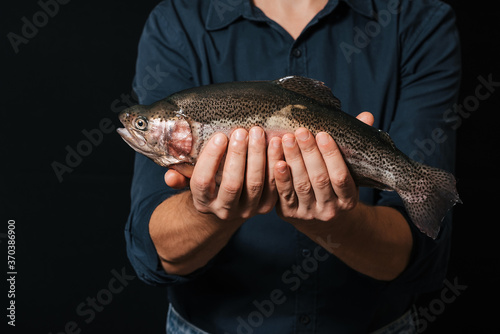Fototapeta Naklejka Na Ścianę i Meble -  man holding a fresh trout. Red fish live