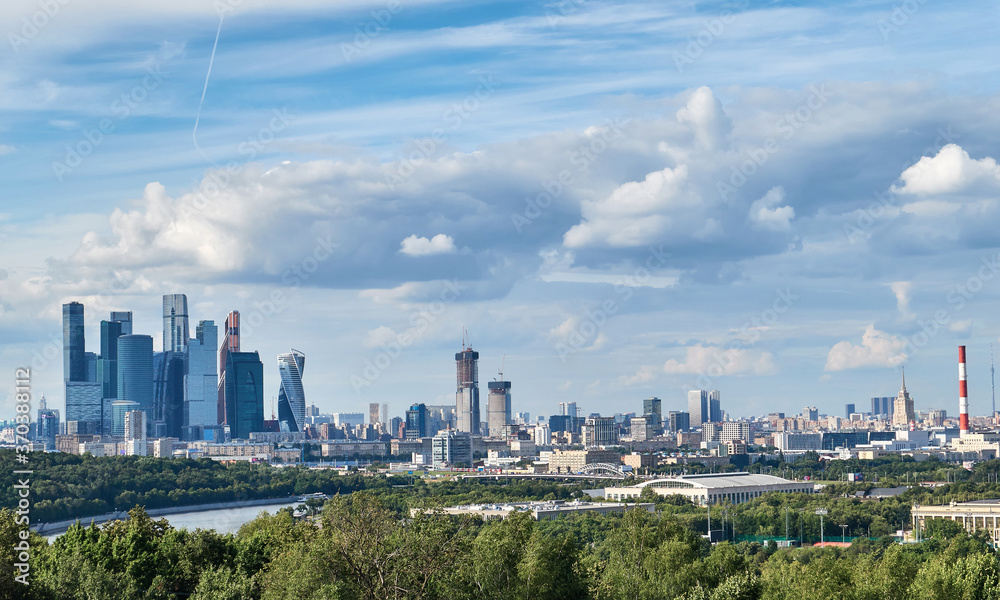 Fototapeta premium Skyscrapers with river reflections under cloudy sky in Moscow city district