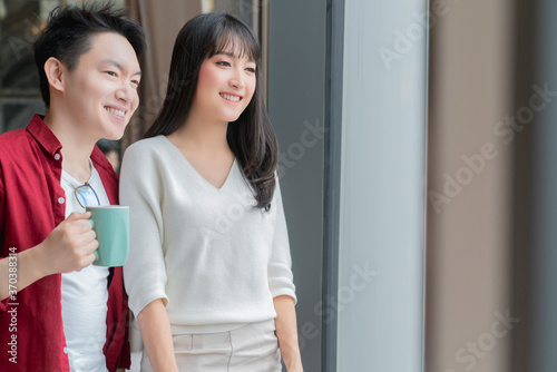 asian marrige couple enjoy weekend vacation with good conversation and coffee home interior background