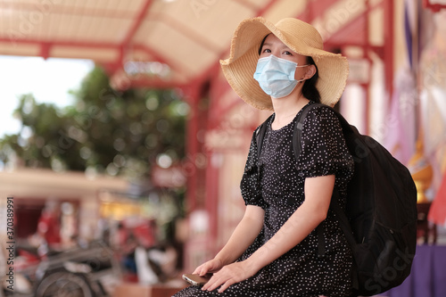 Asian travelers girl in train station with medical face mask to protection the Covid-19, new normal lifestyle