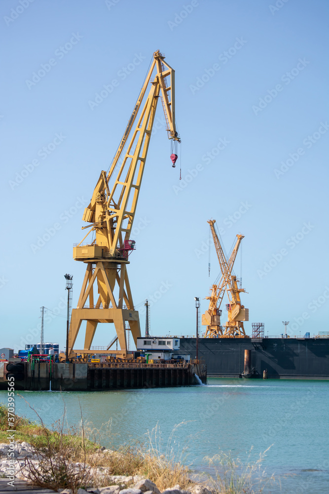 Cranes to repair boats in the bay of Cadiz capital, Andalusia. Spain. Europe. July 01, 2020
