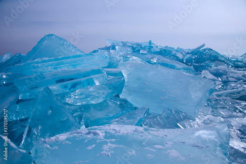 Lake Baikal in winter. Beautiful view of frozen water. Textured blocks of clear blue ice. Mountains and icy texture landscapes. Observation of wild world. Adventure on lake Baikal, Russia