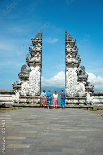 Hindu temple gates Instagram famous location for travellers taking solo photograph wearing Sarong with blue background sky in Bali