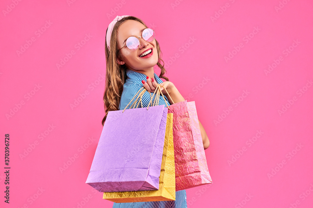 Lovely woman with shopping bags over pink background