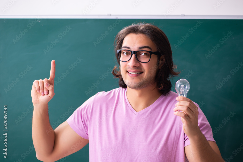Young male student in front of board