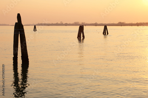 Venice lagoon at sunset with bricole from Cavallino