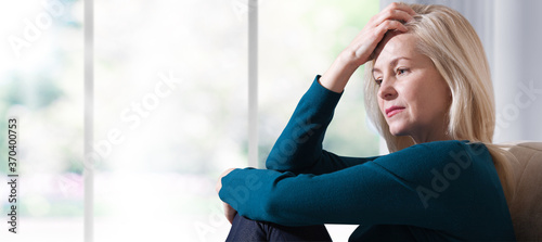 Foto Woman suffering from stress or a headache grimacing in pain