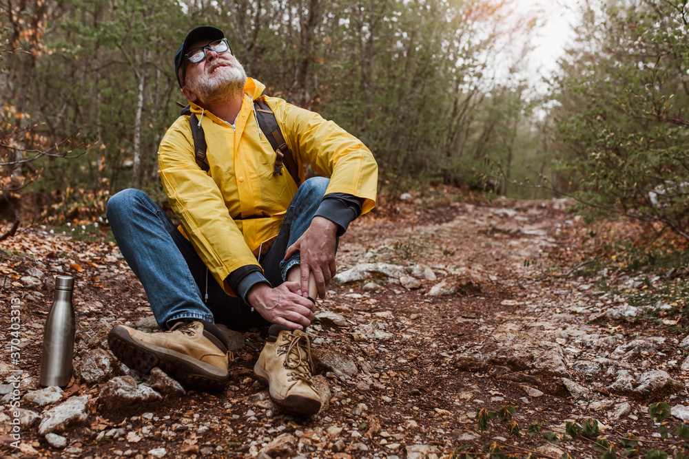 Mature man having injury on his leg on the way Mature man having injury on his leg on the way