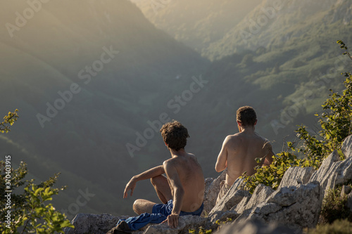 Friends enjoying the sunset in the Asturian mountains valley, Spain photo