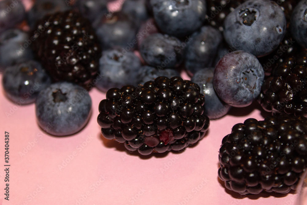 Blueberries and blackberries on a pink background Blueberries and blackberries on a pink background