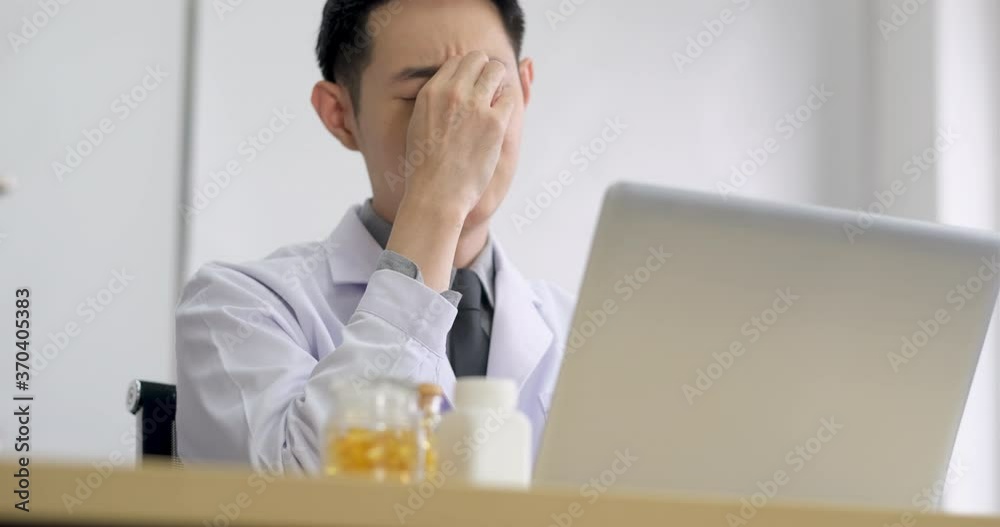 Doctor who is tired from work. Eyes tired from looking at a computer