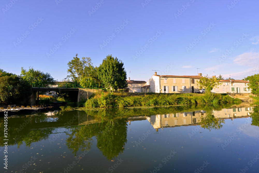 Barques et reflets des maisons sur la Sèvre Niortaise à Damvix (85420), Vendée en Pays de la Loire, France