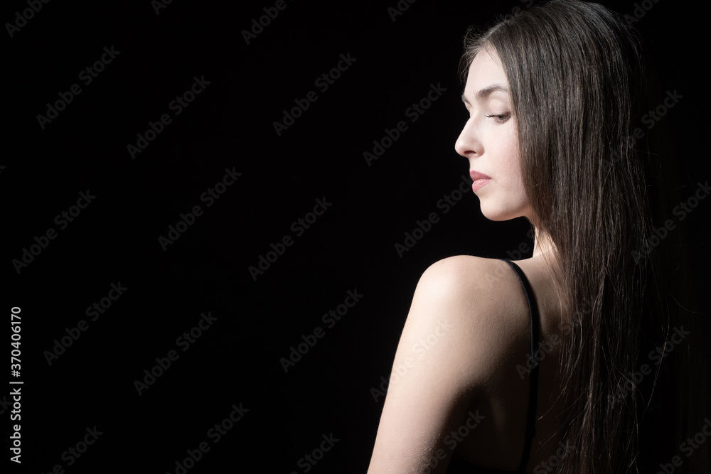 A long-haired girl on a dark background. A girl in an open dress stands with her back to the camera. Serious woman on a black background. The girl looks down. A long-haired girl on a dark background. A girl in an open dress stands with her back to the camera. Serious woman on a black background. The girl looks down.