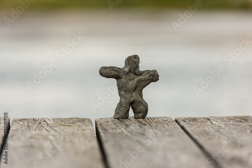 Fototapet Small clay figure made of sand on a beach