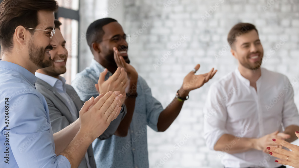 Excited diverse employees clapping hands, applauding and cheering, celebrating business achievement, sharing success, congratulating colleague with promotion, standing in modern office Excited diverse employees clapping hands, applauding and cheering, celebrating business achievement, sharing success, congratulating colleague with promotion, standing in modern office