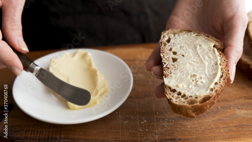 Photos Bread and butter. Smearing butter on sourdough bread