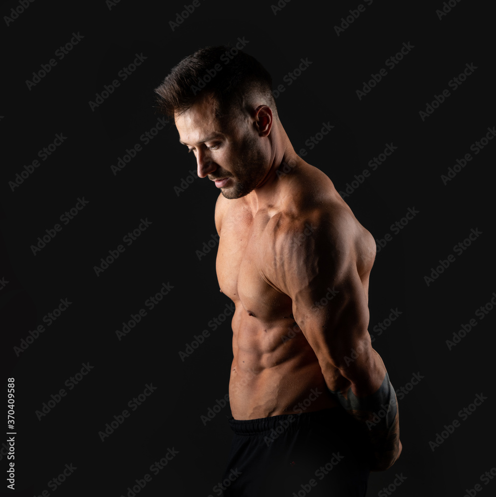 Fototapeta premium Handsome muscular male bodybuilder on a black background. Strong man.