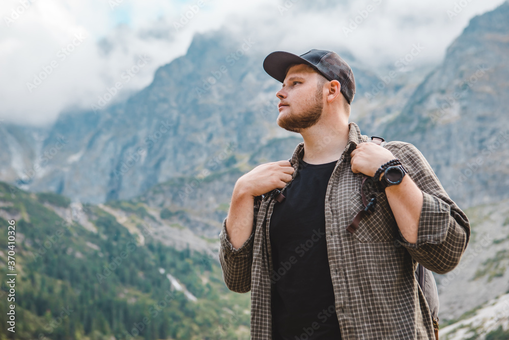 portrait of strong hiker man in front of lake in mountains