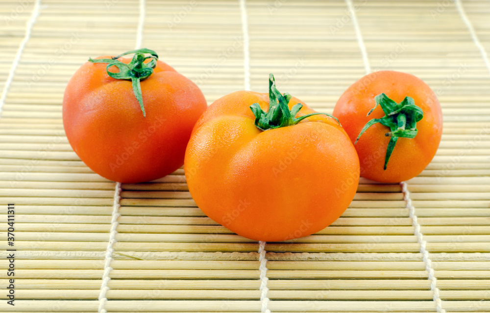 three red tomatoes on a wooden background close up three red tomatoes on a wooden background close up