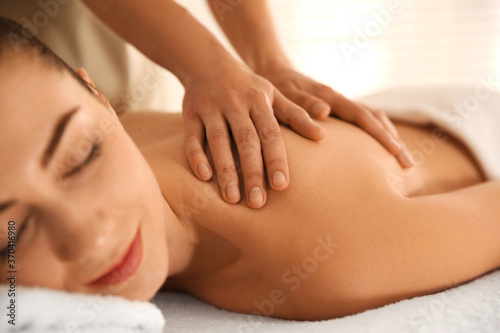 Young woman receiving back massage in spa salon, closeup