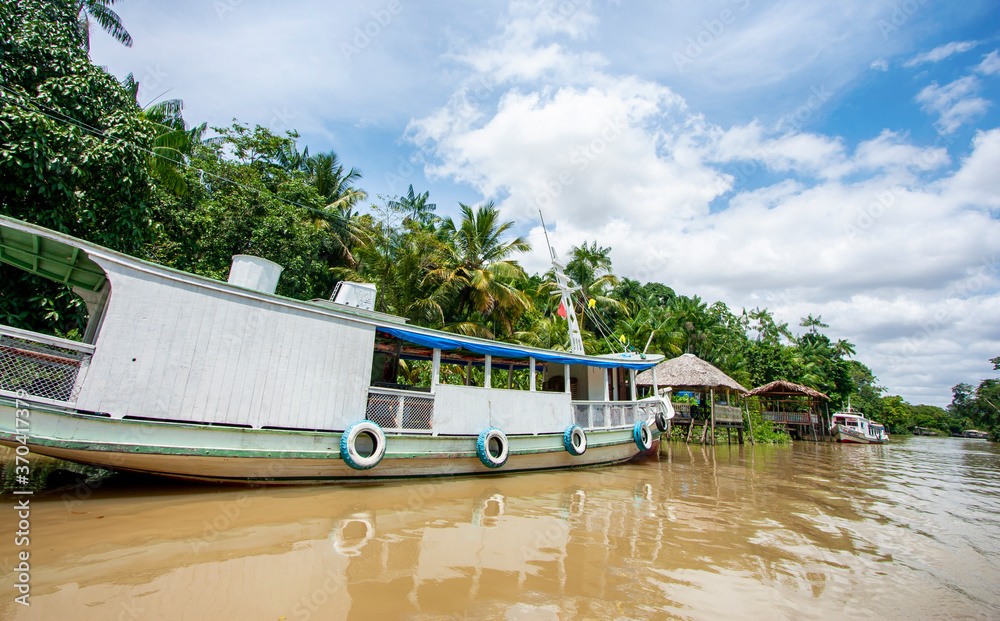 Embarcação de madeira ancorada em trapiche em um rio da floresta amazônica. Barco na margem de floresta sem pessoas